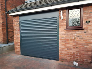 Anthracite grey modern garage door on a red brick house exterior