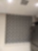 Grey and white geometric patterned roller blind against a neutral wall