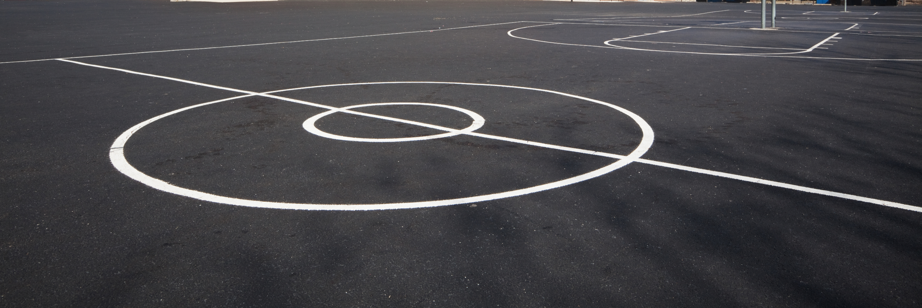 A basketball court featuring white lines marking the boundaries and key areas for gameplay