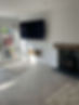 Modern living room with a wall-mounted flat screen TV and minimalist white walls