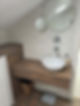 Modern bathroom with a white vessel sink on a wooden vanity and a large round wall mirror