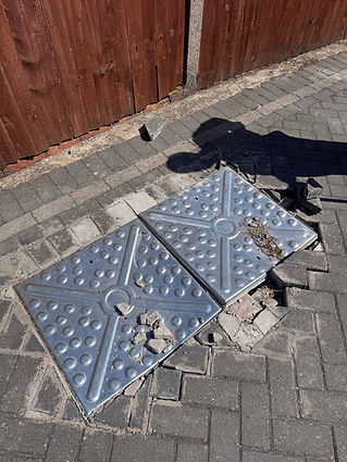 A damaged manhole cover on the ground