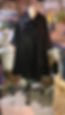 Blurred silhouette of a person wearing a long black garment in a colorful indoor setting