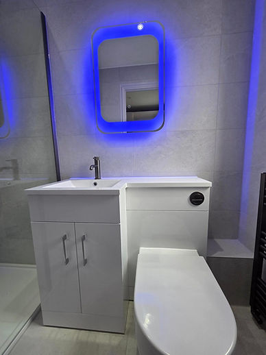 Modern bathroom with a white sink and cabinet beside a toilet