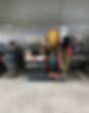 Industrial machine with coiled hoses in red, blue, and yellow is set against a metal wall