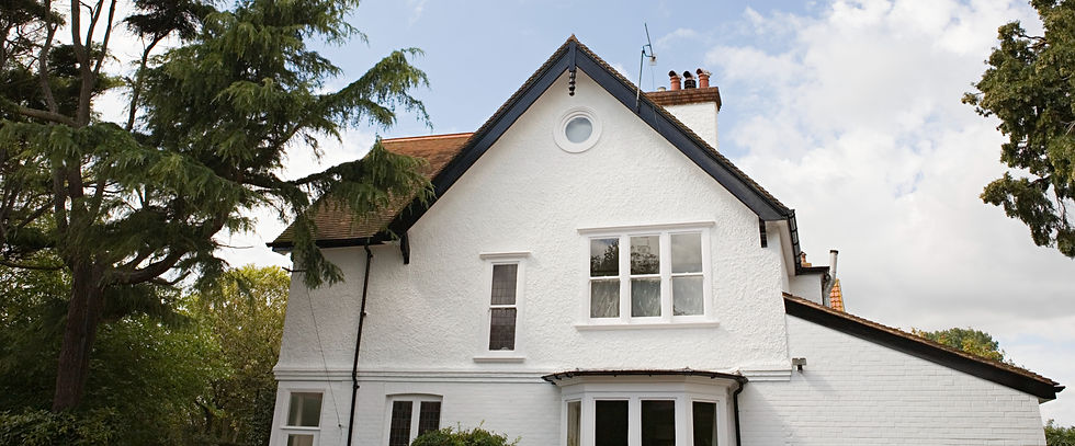 Large residential house with clean white rendered walls and a black roof for a Manchester rendering services website banner