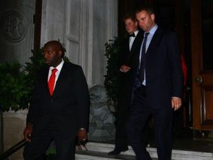 Security guard in a suit standing outside a building entrance