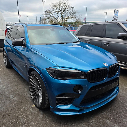 Metallic blue BMW X5 SUV featuring custom multi-spoke alloy wheels and blacked-out kidney grilles