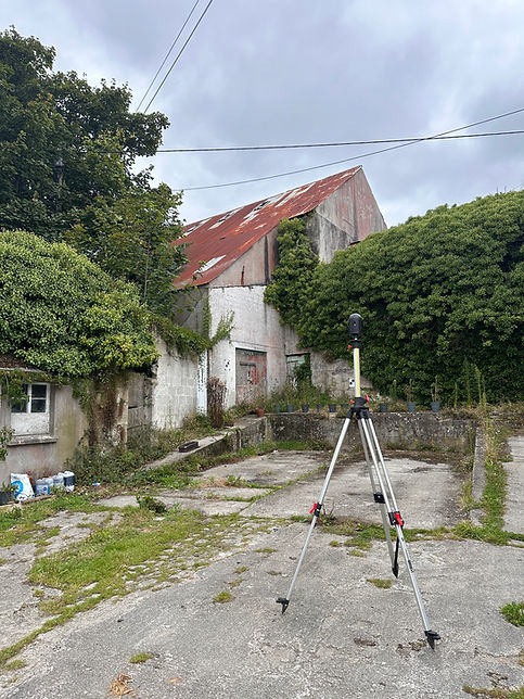 outdoor view of a white house with a red roof surrounded by green trees and leafy foliage under a cloudy sky