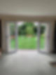 Open double doors lead to a lush green