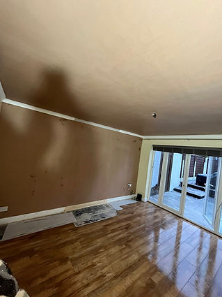 Blurred interior view of an empty room with a brown brick wall and polished wood flooring
