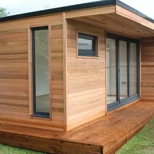 Modern wooden tiny house with a flat roof and large glass doors