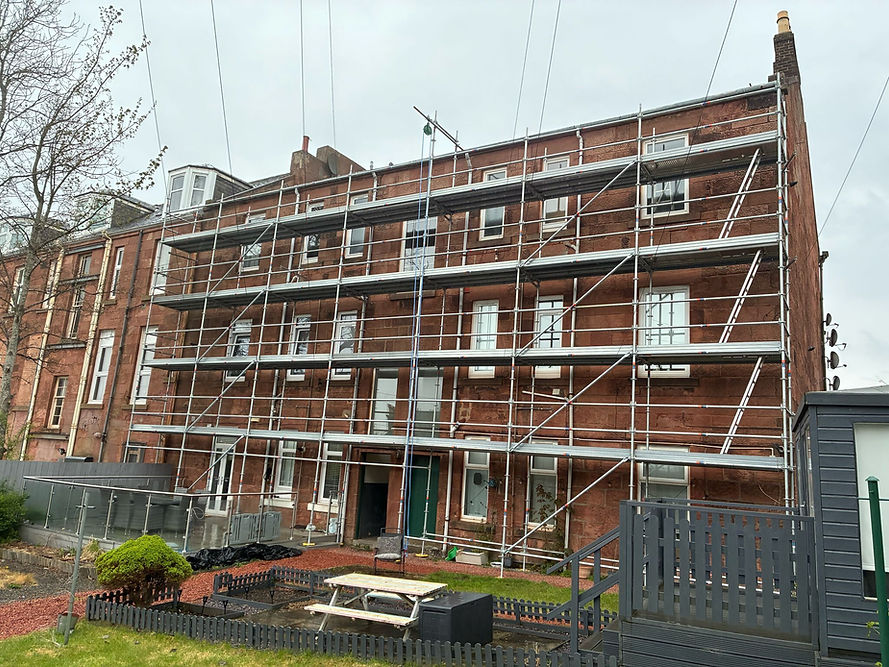 Three-story red brick building with scaffolding for renovation