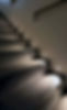 Dimly lit modern stairs with small circular lights embedded in the walls