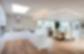 Modern kitchen and dining area with white cabinets, hardwood floors, and large windows