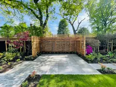 Paved seating area with timber screen and planting borders