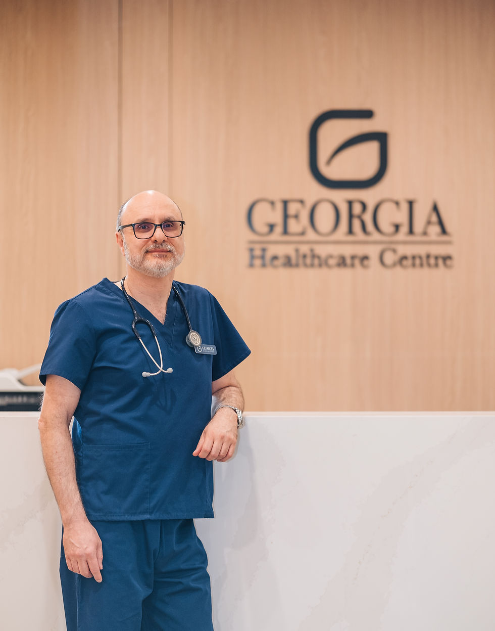 Dr. Payman Nabai smiling doctor with stethoscope stands by Georgia Healthcare Centre in Vancouver, BC