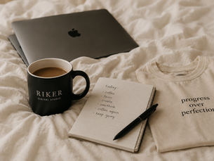 Cozy coffee and laptop workspace on a cream bed with notebook and minimalist apparel, reflecting the coffee culture lifestyle, creativity, and calm productivity.