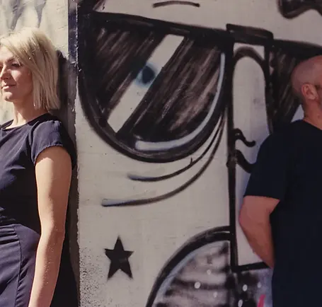 Kamila und Cepp an Wand lehnend
