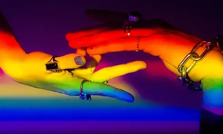 Hände, die sich berühren in farbigen Licht