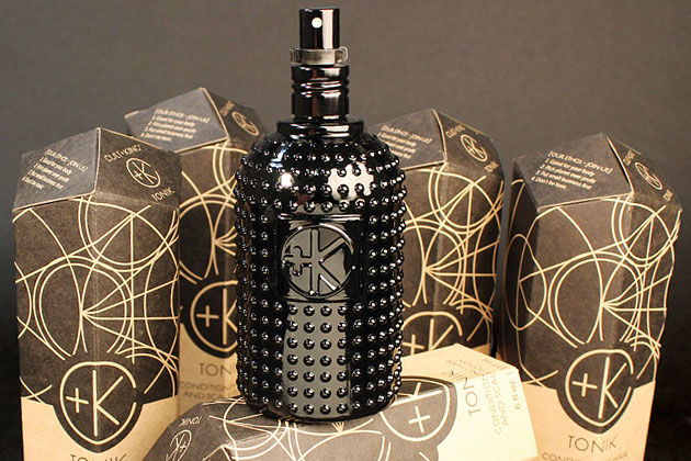 A beautiful black bubble-glass bottle with spray nozzle surrounded by several kraft paper boxes printed with sacred geometry designs. The boxes read "CULT+KING Tonik"