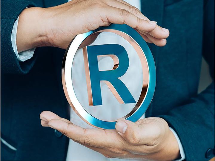 Mãos protegendo o símbolo de marca registrada