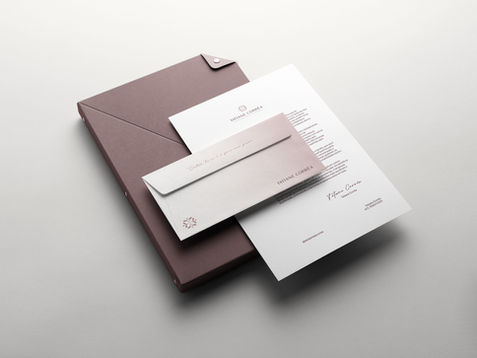 Envelope e cartão Tatiane Corrêa em branco com logotipo vinho sobre superfície neutra