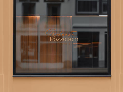 Fachada de estabelecimento com logotipo Roberta Pozzobom em vidro iluminado