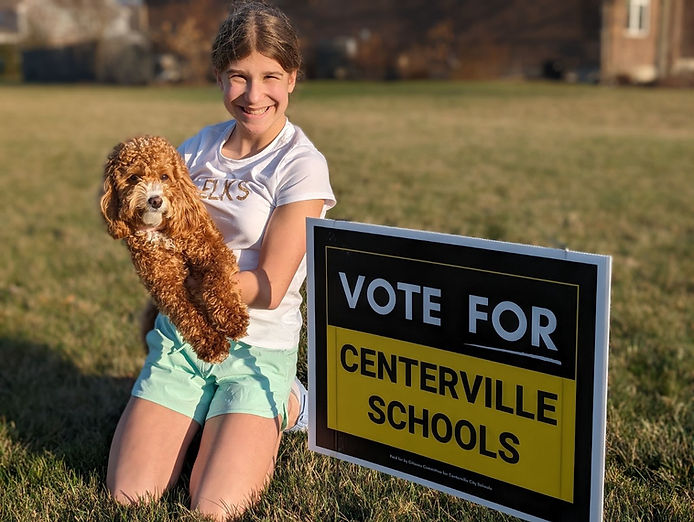 Student with Vote For Centerville Schools yard sign
