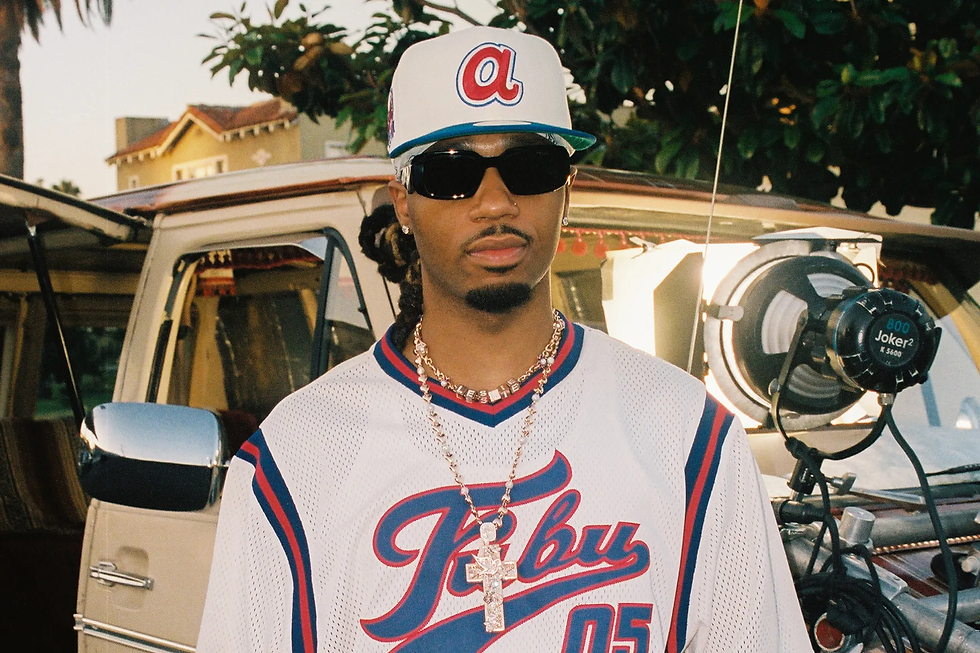 Portrait of Metro Boomin, wearing Fubu jersey, standing in front of car, taken as part of a press photo shoot.