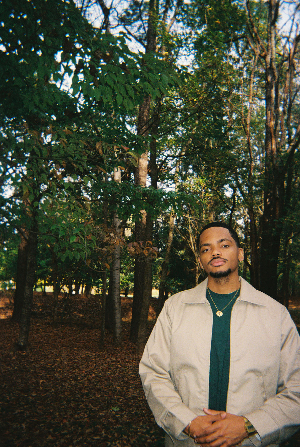 Kinrose posing outdoors with natural light, embodying the blend of his rural roots and urban artistry.