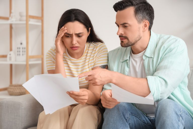 couple looking concerned at paperwork