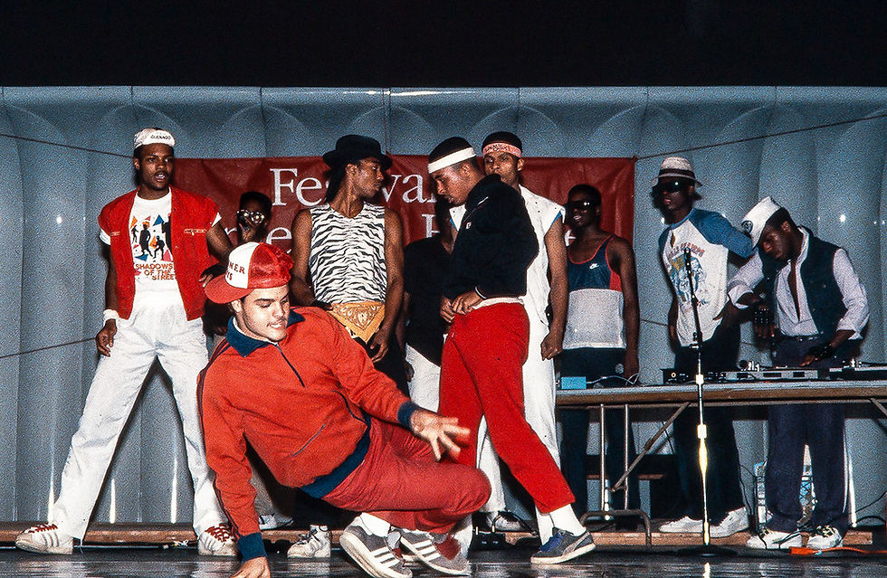 Dancers show off their breakdancing skills in vibrant streetwear during a lively performance at the Festival of Hip-Hop, capturing the energetic spirit of the era.