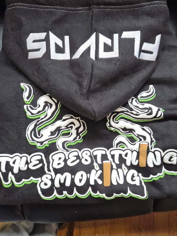 Eye-level view of clothing rack with green and earth-toned hoodies