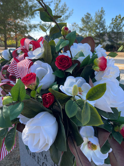 Red and white cemetery headstone display placed at Pinnacle Memorial Gardens in Rogers, Arkansas.