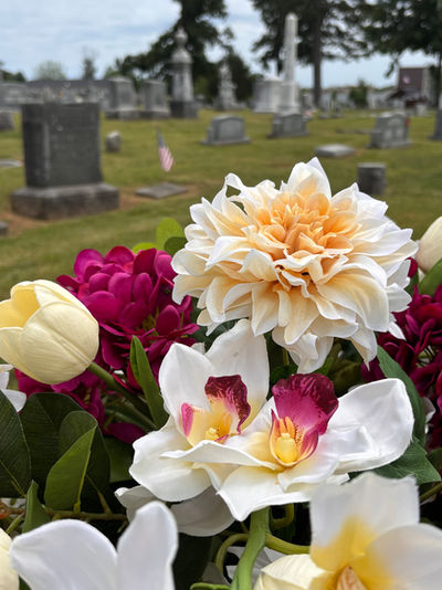 Soft pastel cemetery flower arrangement in vase with yellow and pink memorial flowers

8.