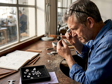 Artisan inspecting diamond at workbench