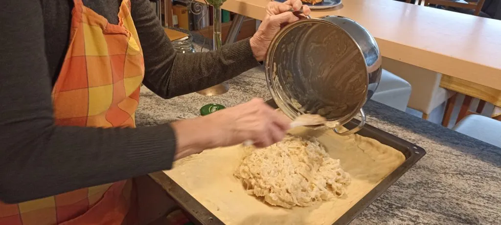 Zwiebeln werden auf dem Teig verteilt