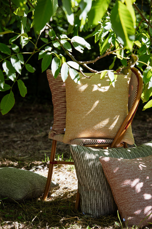 Outdoor cushions on a rattan chair in the garden
