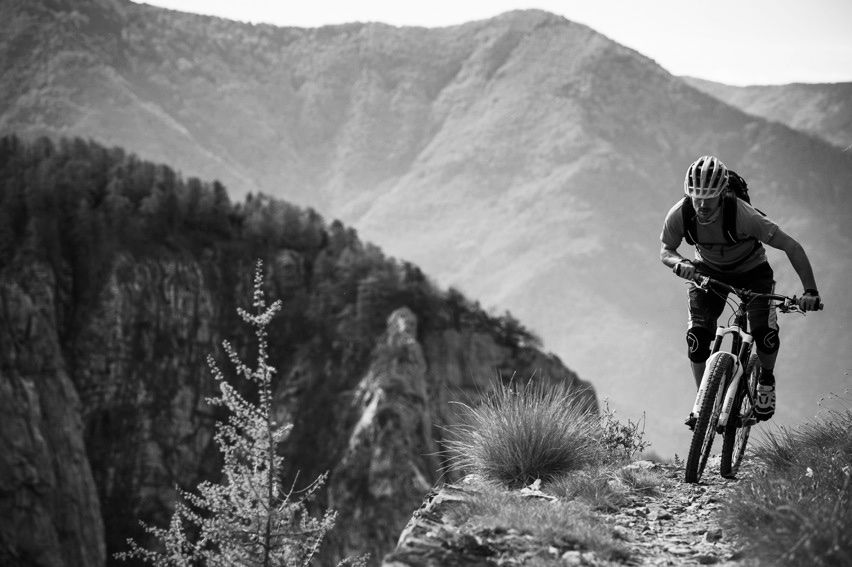 Black and white image of mountain biker with mountain background