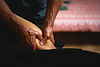 Hands giving deep tissue massage to lower leg