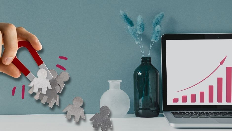 mano con calamita che attrae clienti su una scrivania con computer