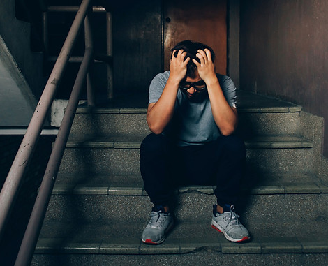 Depressedmansittingonthestairsinbuilding