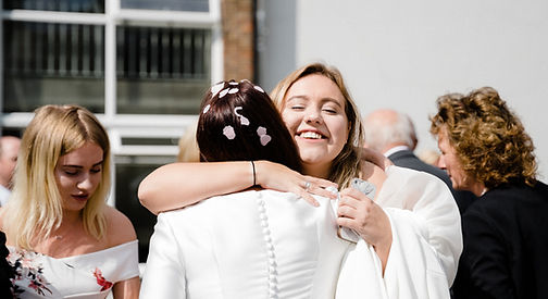 Tiz hugging a Bride at a ceremony