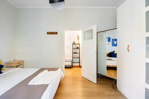 Vista della spaziosa camera da letto con armadio e ingresso in un appartamento vacanze a Monteverde, Roma.