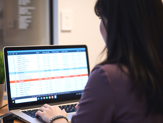 point of view over the shoulder of a woman looking at a computer. She is working on a mail
