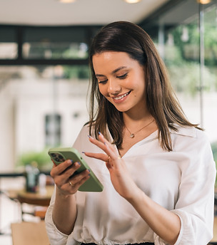 Hispanic businesswoman in formal attire in her office happy and cheerful while using smart