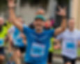 Runner che finisce gara con braccia al cielo