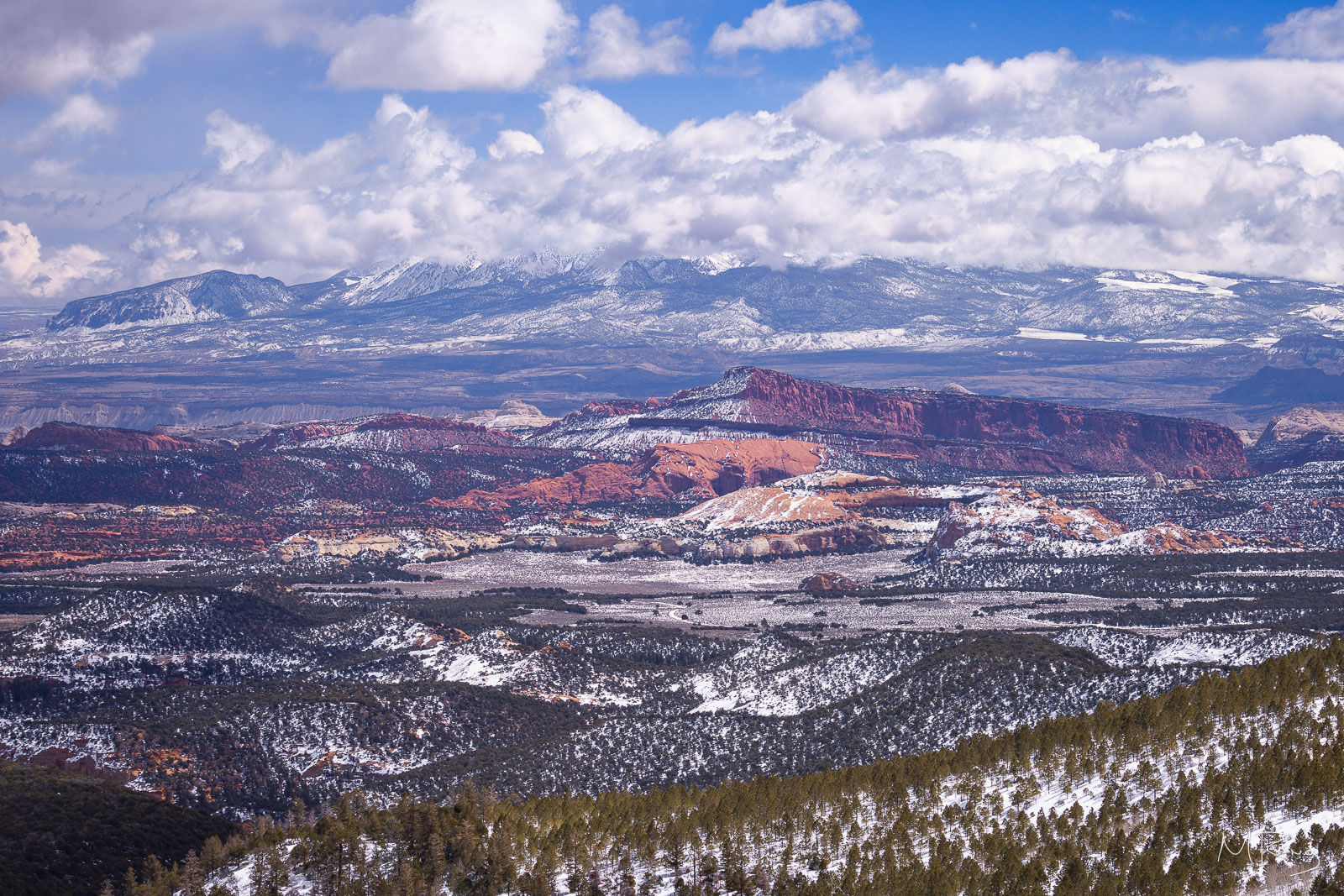 A grand vista of snowcapped mountains and winter storm clouds along Highway 12 in Utah