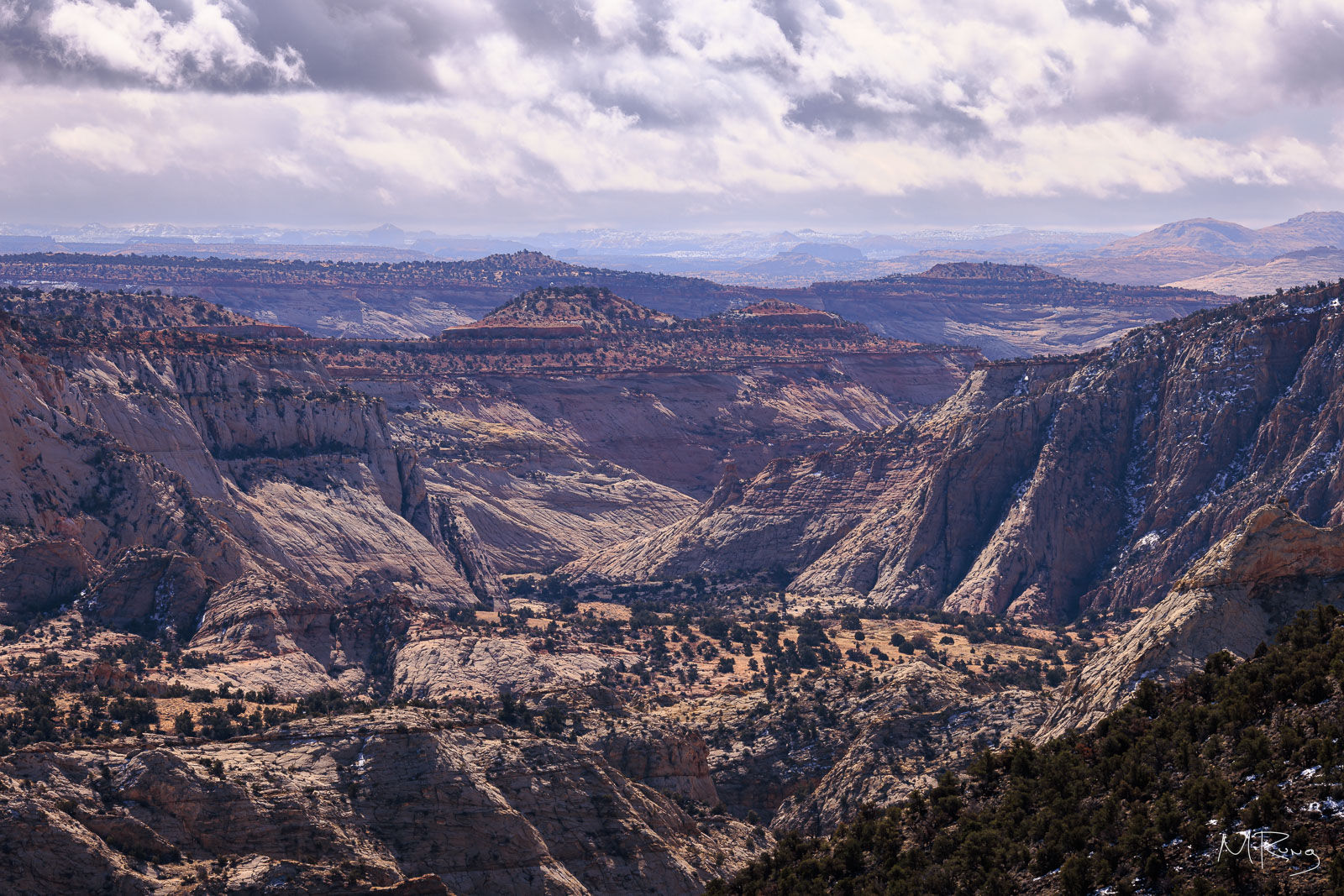 A rugged canyon landscape along Utah Highway 12, with sunlit storm clouds overhead